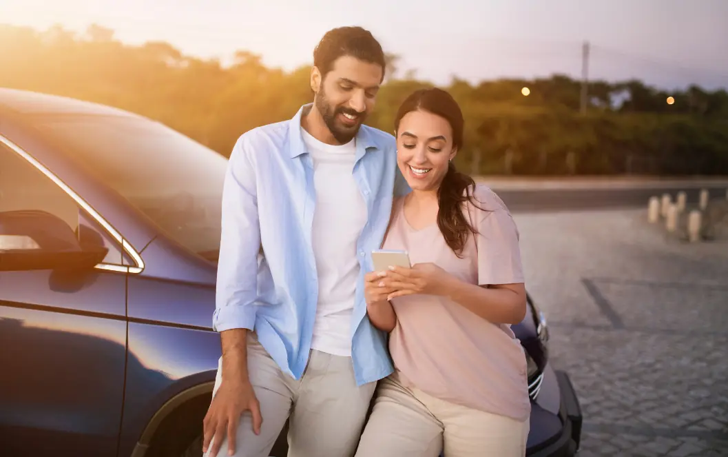 Fertility clinic marketing UAE: Couple smiling together beside a parked car for the fertility demand section, supporting fertility patient acquisition