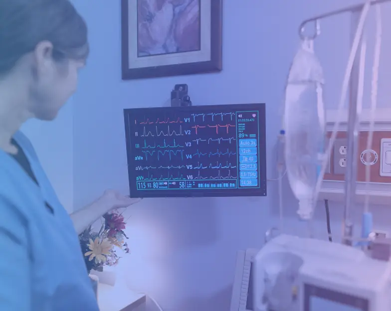 Medical and dental marketing in UAE: Clinician beside a monitor displaying cardiac traces in a consultation room for Cardiology, Endocrinology and Metabolic Care