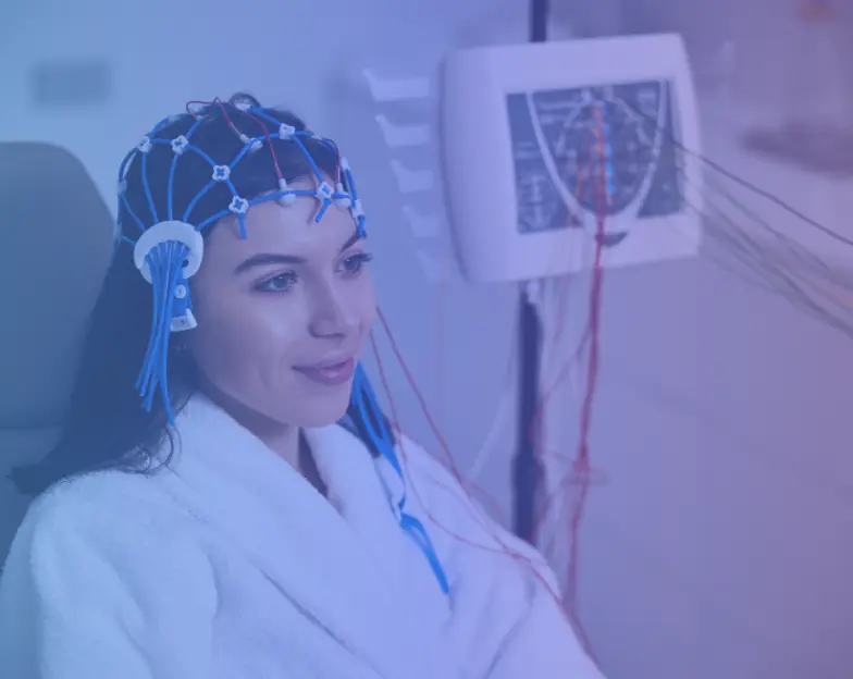 Medical and dental marketing in UAE: Person wearing an electrode cap beside monitoring equipment for Neurology and Neurosciences, supporting specialty-led healthcare marketing