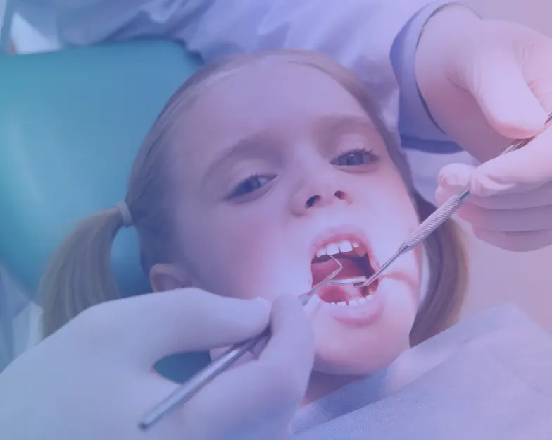 Medical and dental marketing in UAE: Child in a dental chair while gloved hands hold examination instruments for Pediatric Dentistry