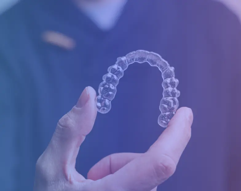 Medical and dental marketing in UAE: Hand holding a transparent dental aligner for Orthodontics and Clear Aligners