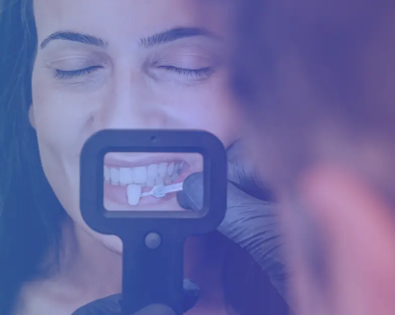Medical and dental marketing in UAE: Dental shade comparison held in front of a smiling woman