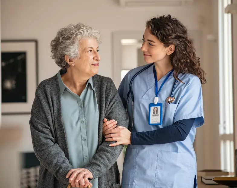 Medical and dental marketing in UAE: Healthcare professional supporting an older woman in a home setting