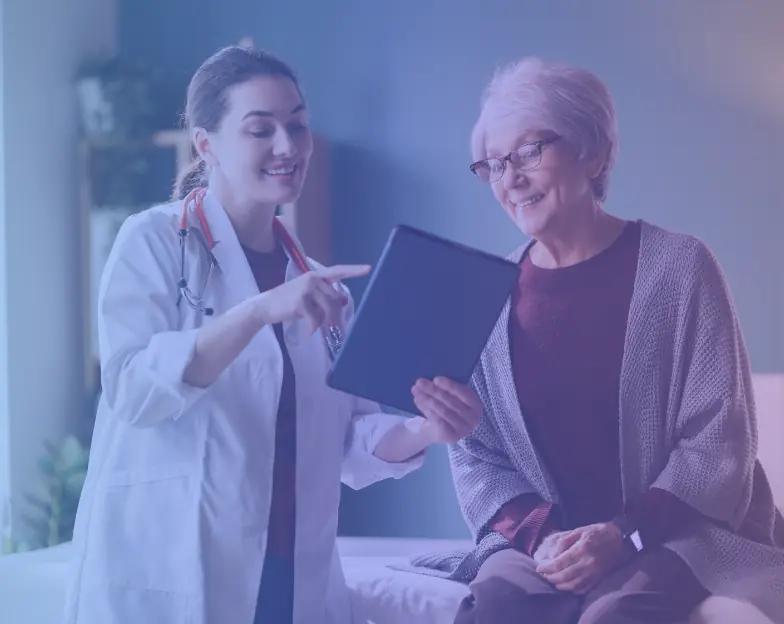 Medical and dental marketing in UAE: Clinician discussing a tablet with an older woman during a consultation for Doctor and Clinical Home Visits