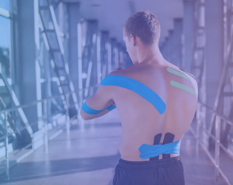 Medical and dental marketing in UAE: Man with coloured support tape across his back in a gym setting for Sports Physiotherapy and Rehabilitation, supporting specialty-led healthcare marketing