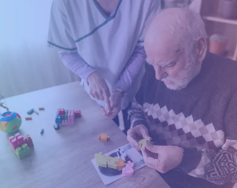 Medical and dental marketing in UAE: Older man handling small objects during a supported tabletop activity for Occupational Therapy, supporting specialty-led healthcare marketing