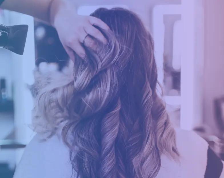 Medical and dental marketing in UAE: Stylist arranging long curled hair in a salon setting for Hair Salons and Hair Services, supporting beauty marketing UAE