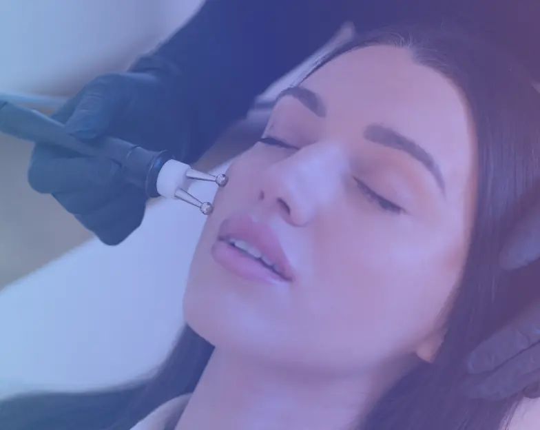 Medical and dental marketing in UAE: Facial-care device held near a reclining woman's cheek for Facial and Beauty-Led Skin Services, supporting aesthetic clinic marketing UAE