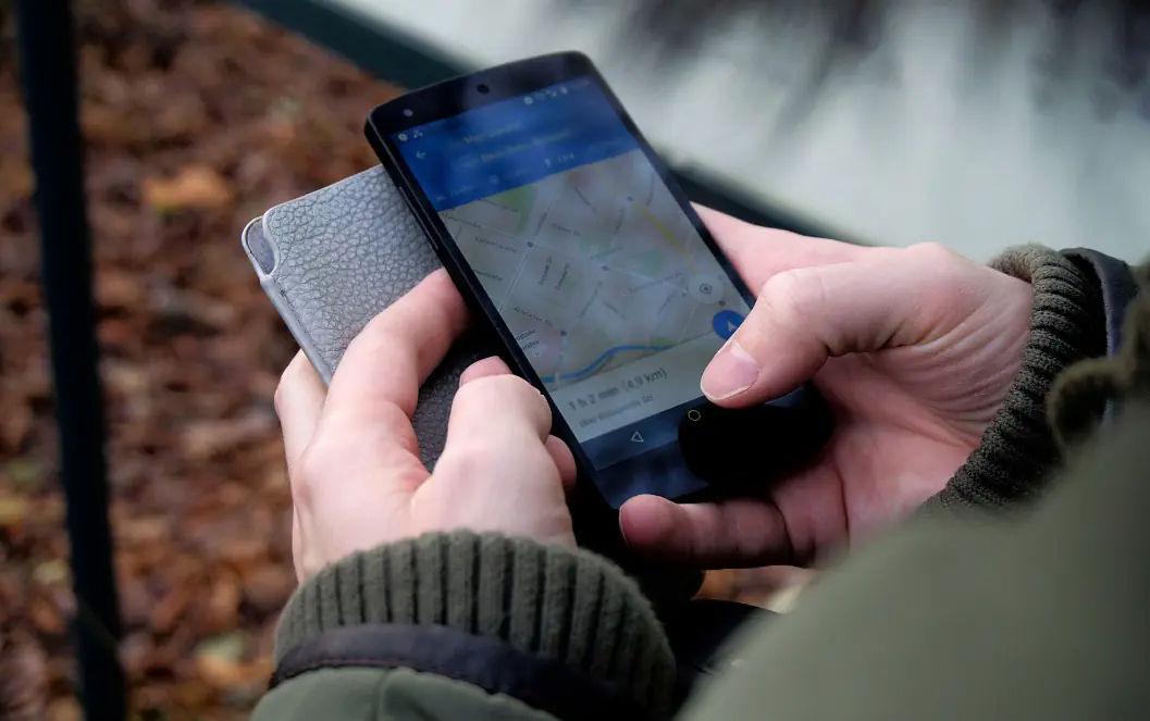 Healthcare SEO insights UAE: Person viewing a map on a smartphone outdoors for Explore other Care Journey Insights topics, supporting technical SEO and search intent