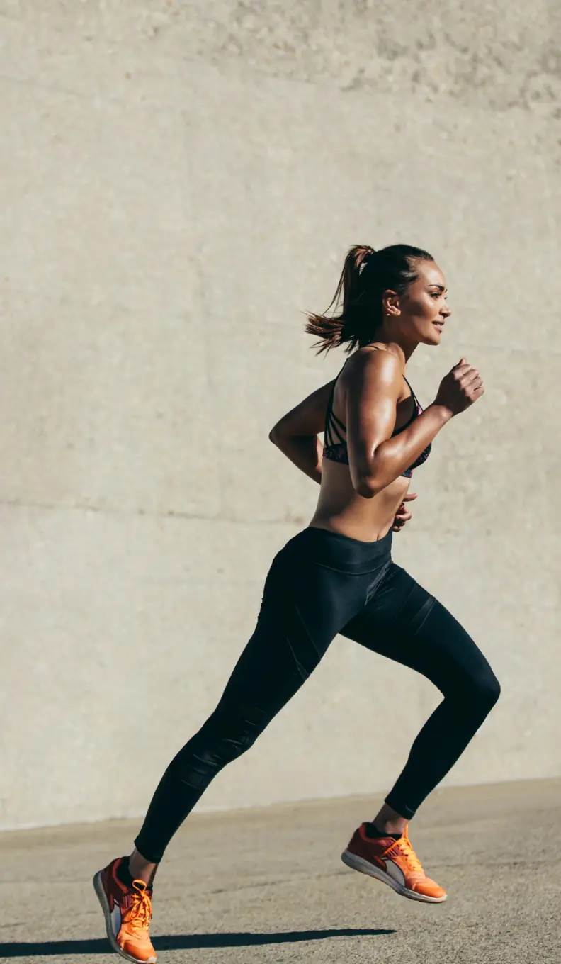 Healthcare marketing packages UAE: Woman running alongside a textured wall in the Performance plan section, supporting SEO and organic visibility